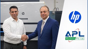 HP and APL Machinery representatives shaking hands beside an HP Indigo digital press