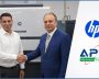 HP and APL Machinery representatives shaking hands beside an HP Indigo digital press