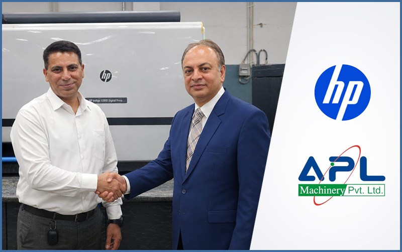 HP and APL Machinery representatives shaking hands beside an HP Indigo digital press